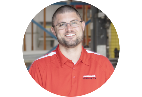 RSC Technical Trainer Mason Bell smiling at the camera in RSC red polo with warehouse in background.