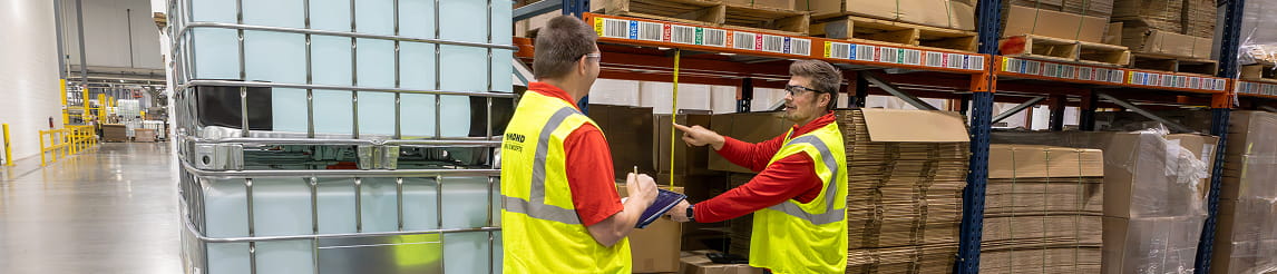 Raymond Storage Concepts engineer measuring pallet and racking spacing while another engineer records the measurements