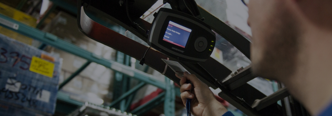 Forklift operator logging into an iWAREHOUSE fleet management monitor.
