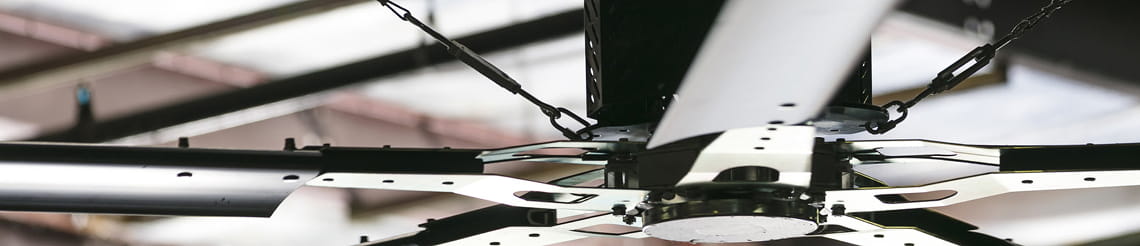 Close-up of a high-volume industrial warehouse ceiling fan.