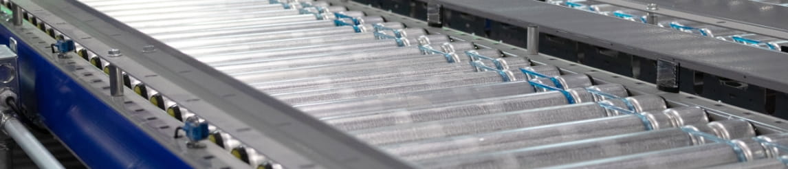 Parallel roller conveyor systems for automated warehouse material transport.