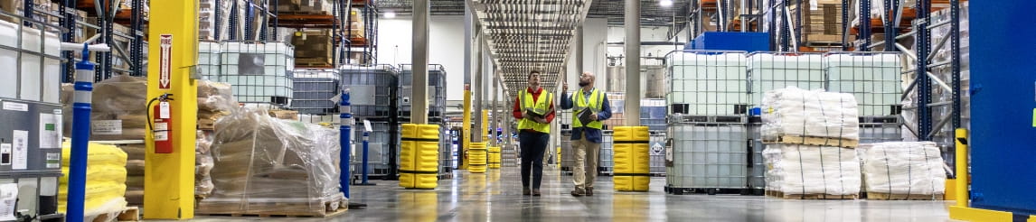 RSC specialist and customer conducting a facility assessment in a warehouse racking aisle.