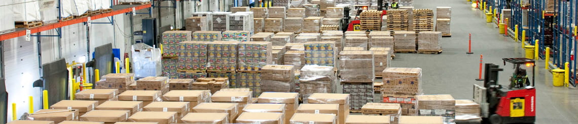 Warehouse staging area managing pallet flow between dock doors and storage racking.