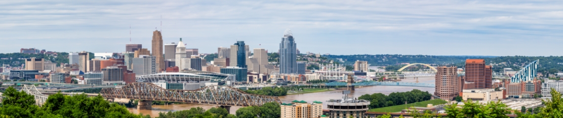 Aerial view of downtown Cincinnati, OH and Newport, KY with skyscraper buildings, Ohio River and bridges.