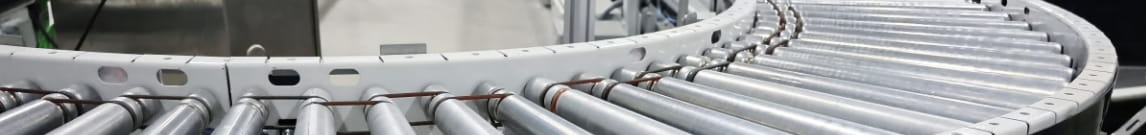 Closeup of a two leveled roller conveyer curve in a warehouse picking area.