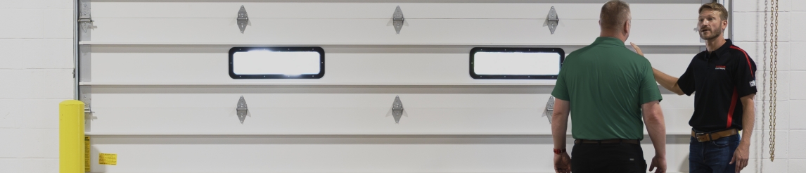 Customer consulting with a RSC Dock & Door Specialist next to a commercial sectional door. 
