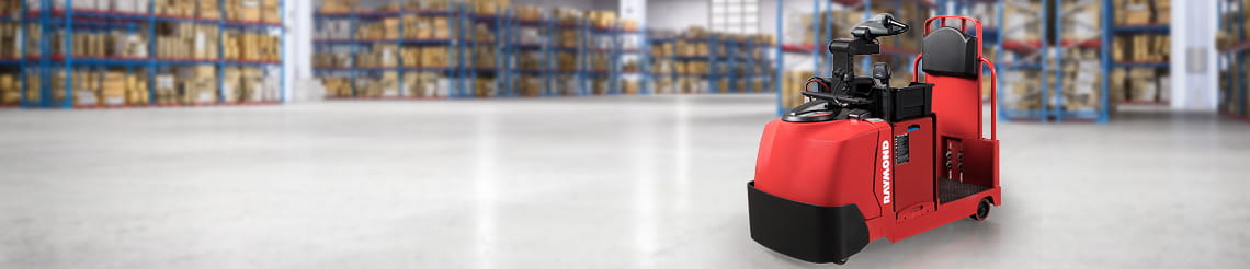 Raymond tow tractor with a warehouse racking in background.