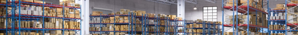 Wide view of racking aisles in warehouse. Racks are full of wrapped pallets.