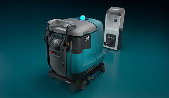 Tennant autonomous floor scrubber plugged into charging station.