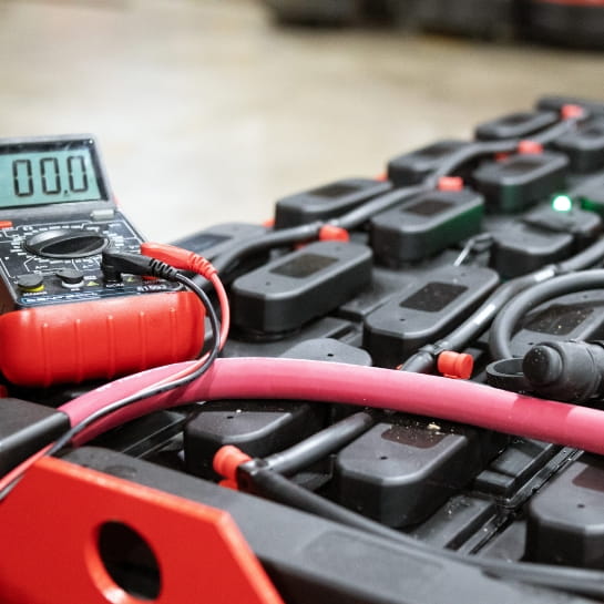 Close up of the lead-acid battery with a meter on top.