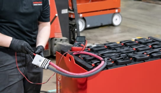 RSC technician using a meter to check the charge on an industrial battery.