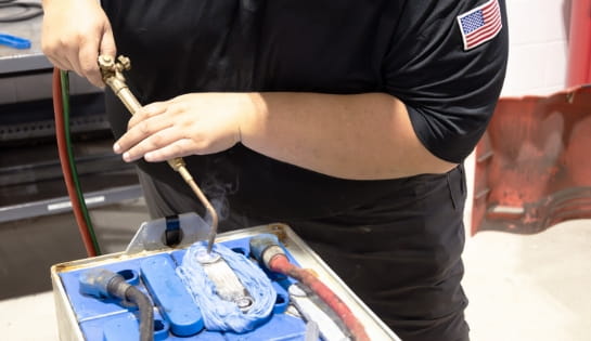 RSC technician welding a part of an lead acid battery during a repair visit.