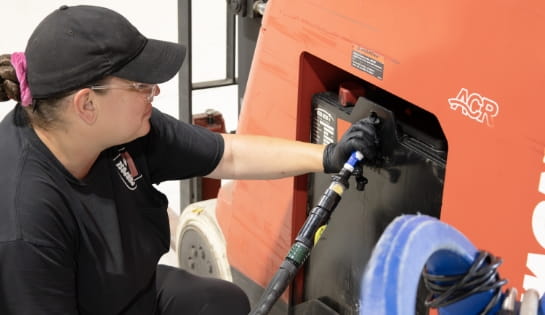 RSC technician watering a lead acid battery that is still in a forklift.