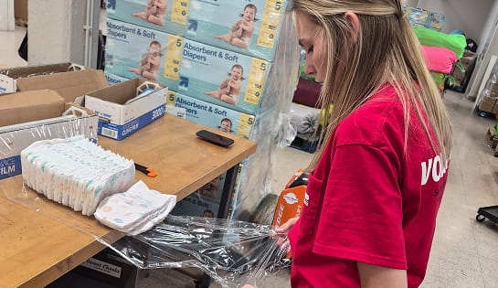 RSC employee wrapping diapers for Sweet Cheeks Diaper Bank inventory.