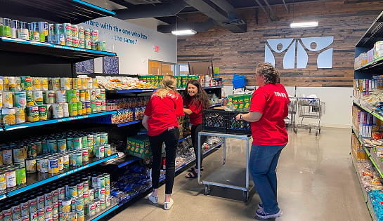 Three RSC volunteering employees restock shelves at St. Vincent dePaul's food pantry in Cincinnati, OH.