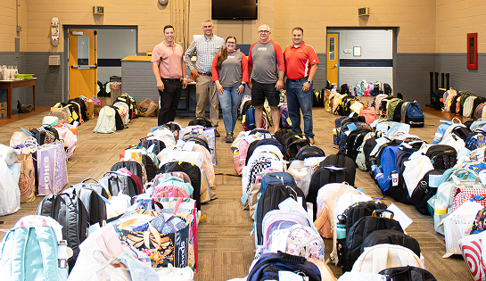 Group of RSC employees volunteer at Joshua's Place, packing backpacks for the school year.