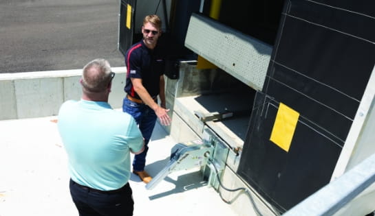 RSC specialist evaluates dock leveler with customer in dock pit.