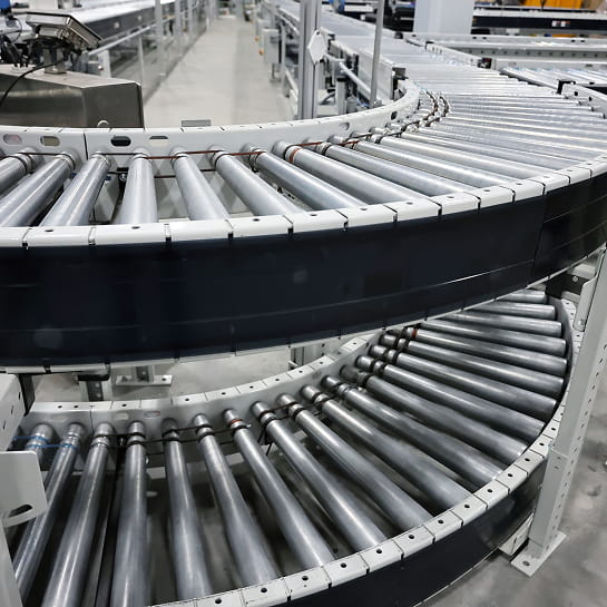 Two-level roller conveyor curve in a warehouse picking area.