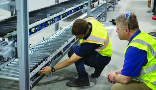 RSC project manager reviewing conveyor system installation progress with man in safety vest.