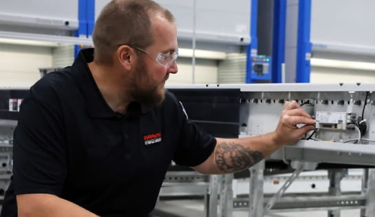 RSCI technician inspecting conveyor motors for loose wires and connections.