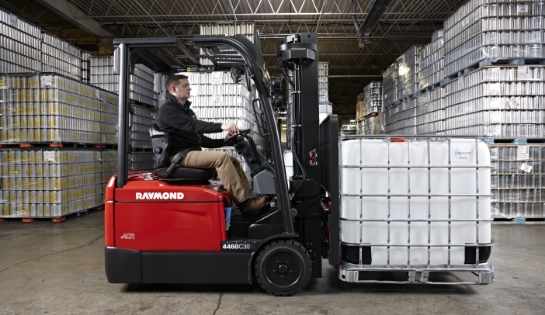 Warehouse driver driving a Raymond counterbalanced truck with a gaylord pallet in a warehouse.