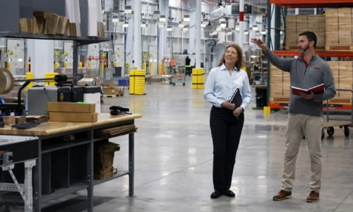 RSCI sales engineer discusses the current state of a warehouse operation with female customer.