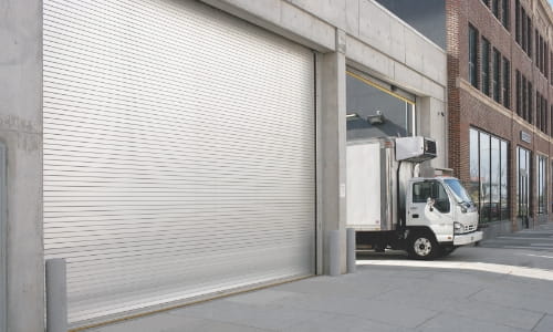 Box truck leaving a warehouse dock area through a dock door