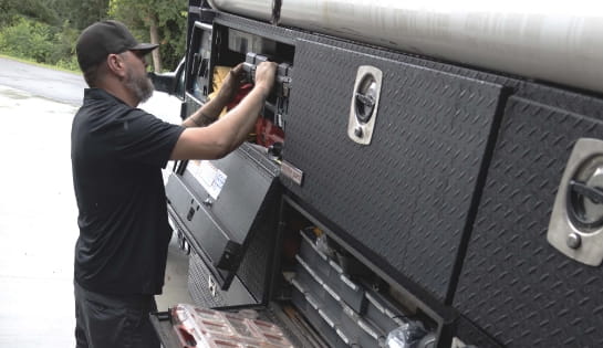 RSC Dock & door technician pulling tools out of his Raymond Storage Concepts Dock & Door truck.