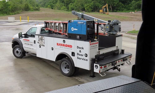 Raymond Storage Concepts Dock & Door service truck backed up to warehouse dock.