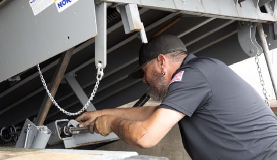 RSC Technician holding a wrench maintaining a dock leveler