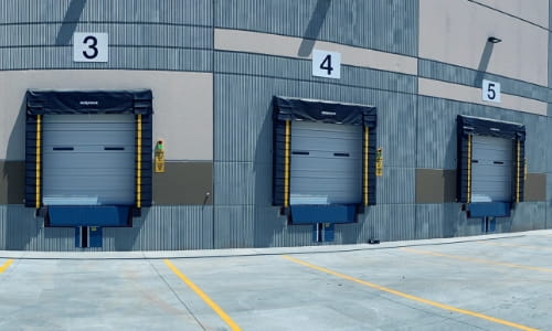 Exterior warehouse loading dock area with two dock doors.