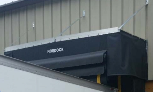 Rain shield over a trailer in a loading area.