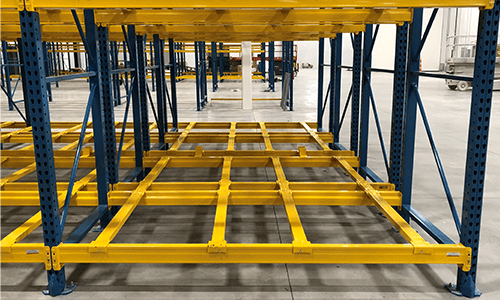 Looking through a blue and yellow, double deep racking in a warehouse