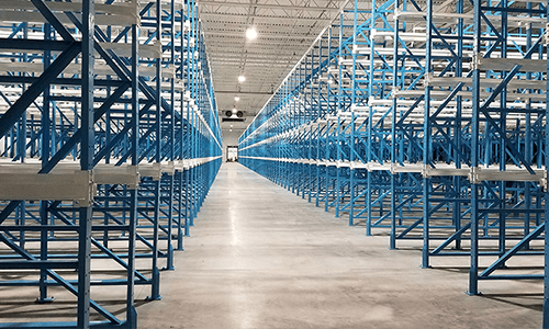 Warehouse full of empty, blue drive in racking.