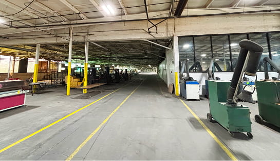 The before view of the Eckart Supply facility in Blue Ash, OH. Featuring old equipment, uneven floors and dim lighting.