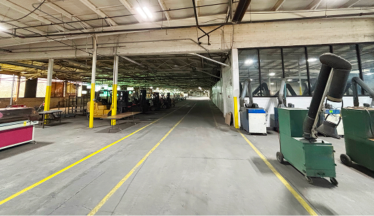 The before view of the Eckart Supply facility in Blue Ash, OH. Featuring old equipment, uneven floors and dim lighting.
