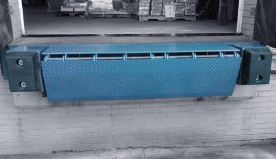 Blue edge mounted leveler in loading dock area