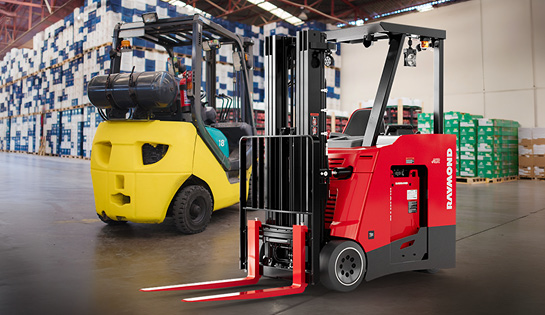 Gas-powered and electric forklifts parked side by side in a warehouse for a power comparison.