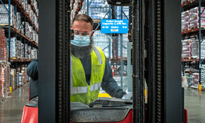 RSCO forklift technician with safety vest and mask wiping down a Raymond lift truck during service call.