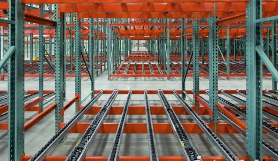Close up of a pallet flow / gravity flow rack in a warehouse.