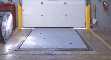 Leveler in horizontal stored position in warehouse loading area.