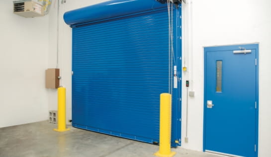 Blue fire-rated door inside a warehouse