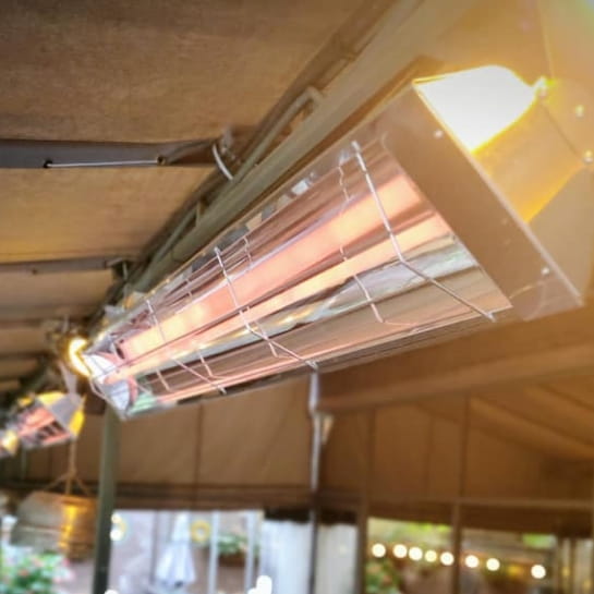 Infrared heaters attached to the ceiling of a building.