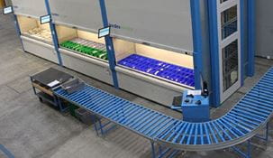 Overhead view of Kardex Remstar automated storage and retrieval system with blue conveyor in front.