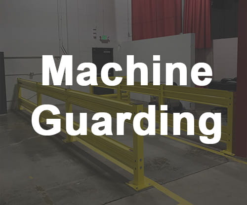 Machine Guarding. Yellow guard rails protecting a pedestrian path in warehouse.