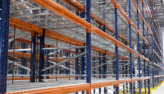 Aisle of single deep pallet rack with wire decks and rack backing.