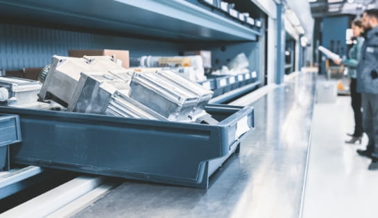 Tote of conveyor parts sitting on shelf in warehouse.