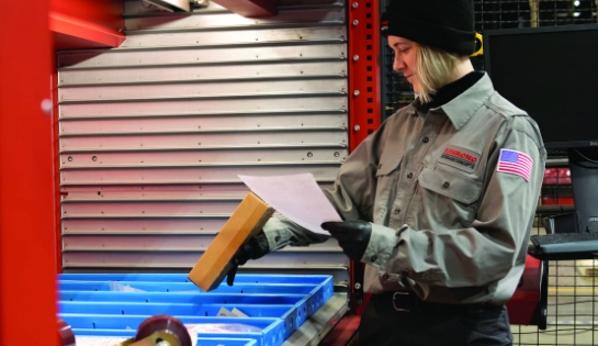 RSCI employee picking parts from work order paper from automatic storage and retrieval system (AS/RS)