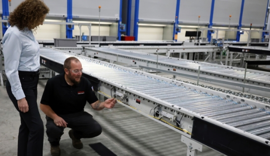 RSCI technician showing a customer a conveyor motor in a receiving line of a warehouse.