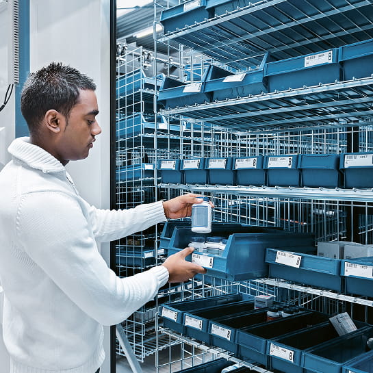 A pharmacist pulls medication from a horizontal carousel AS/RS.